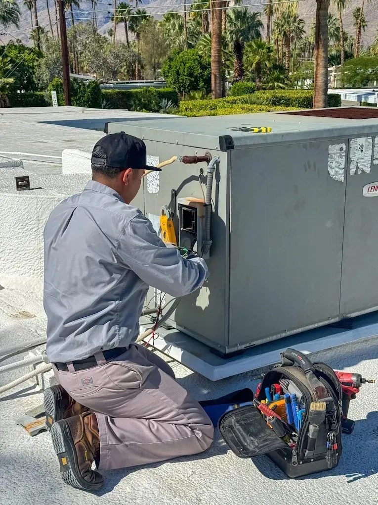 Spring AC Tune-Up Checklist for Summer Readiness 4 Technician inspecting electrical connections in an air conditioning unit